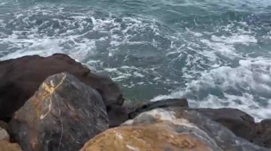 Her gün denizin dalgalarında olan büyük bir kaya.