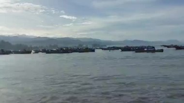 Diğer taraftaki karanlık koşullarda güneybatı limanından geçen gemiler.
