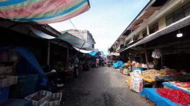 Güneybatı Aceh, Endonezya - 25 Haziran 2022: Güneybatı Aceh Sebze Pazarı 'nda yürürken tüccarlara bakıyor