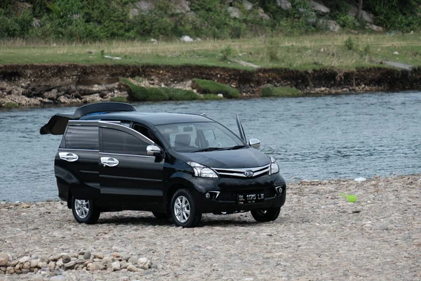 Aceh Barat Daya, Endonezya - 6 Ağustos 2022 Blangpidie 'de bir nehrin kenarında yıkanmış siyah bir Toyota avanza arabası.