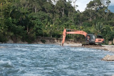 Aceh Barat Daya, Endonezya - 7 Ağustos 2022 Aceh Barat Daya, Endonezya - 7 Ağustos 2022 Hızlı su akışı seçici odak noktasında çekilmiş bir nehirde kumu kazan bir ekvatorun