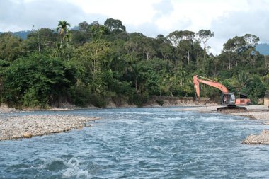 Aceh Barat Daya, Endonezya - 7 Ağustos 2022 Blangpidie Abdya 'da bulunan temiz bir nehrin kumunu kazan ekvatorun seçici odak noktasında fotoğrafı çekildi.