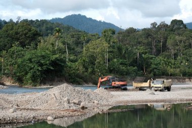 Aceh Barat Daya, Endonezya - 7 Ağustos 2022 Bu doğal bir görüntü Oren renkli bir kazı aracı ve Blangpidie Abdya 'da bulunan bir kum nakliye aracı gösteriyor