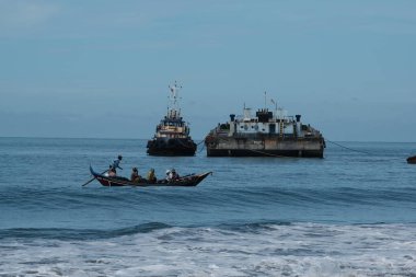 Aceh Barat Daya, Endonezya - 7 Ağustos 2022 Küçük bir balıkçı teknesi sularda hareketsiz duran iki balıkçı teknesini geçiyor