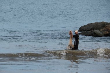 Aceh Barat Daya, Endonezya - 6 Ağustos 2022 Balıkçılar öğleden sonra suşi Abdya sahilinde ağlarıyla balık arıyorlar.