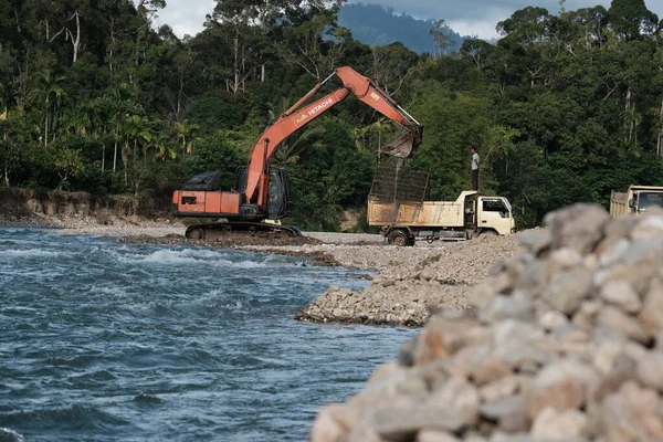 Aceh Barat Daya, Endonezya - 7 Ağustos 2022 Ekvator nehirden gelen kumu Abdya 'da bulunan sarı bir kum kamyonuna yerleştiriyordu.