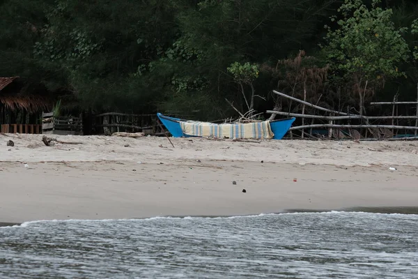 A small boat wrapped in cloth is placed on the beach in Susoh Aceh Barat Daya in August 2022