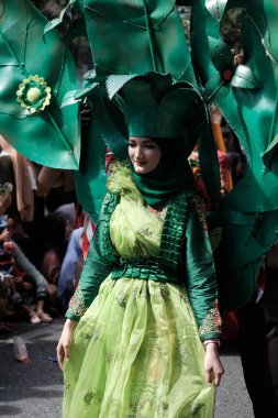 Banda Aceh, Endonezya - 18 Ağustos 2022 Bu kız, 77. Endonezya Bağımsızlık Günü 'nde yegâne yeşil elbisesiyle Karnaval geçit törenine katılıyor.