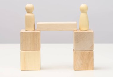 Tahta figürler köprüde yan yana duruyorlar, uzlaşma konsepti, yapıcı diyalog, iş karşıtları