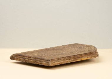 Sarı arka planda boş kahverengi ahşap mutfak tahtası, çatal bıçaklar.