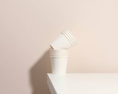 Kahve için kağıt beyaz bardaklar, bej arka plan. Çevre dostu sofra takımı, sıfır atık