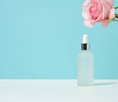 Pipetli beyaz cam şişe mavi arka planda duruyor. Kozmetik SPA markası. Jel, serum, reklam ve ürün tanıtımı için ambalaj, maket
