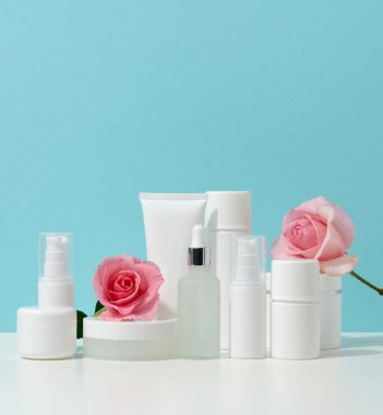 Kavanoz, şişe ve beyaz bir masada kozmetik ürünleri için boş plastik tüpler. Krem, jel, serum, reklam ve ürün tanıtımı için ambalaj, maket