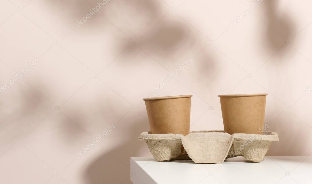 paper cardboard brown cups for coffee and tea, beige background. Eco-friendly tableware, zero waste