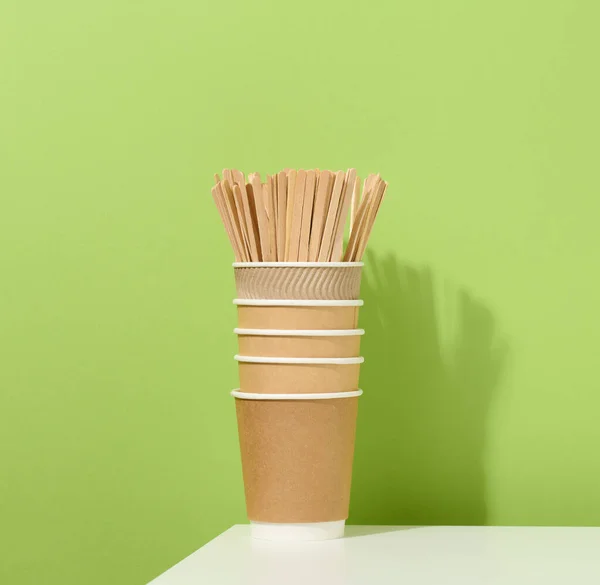 Brązowe Papierowe Kubki Kartonowe Drewniane Kije Mieszające Białym Stole Zielone — Zdjęcie stockowe