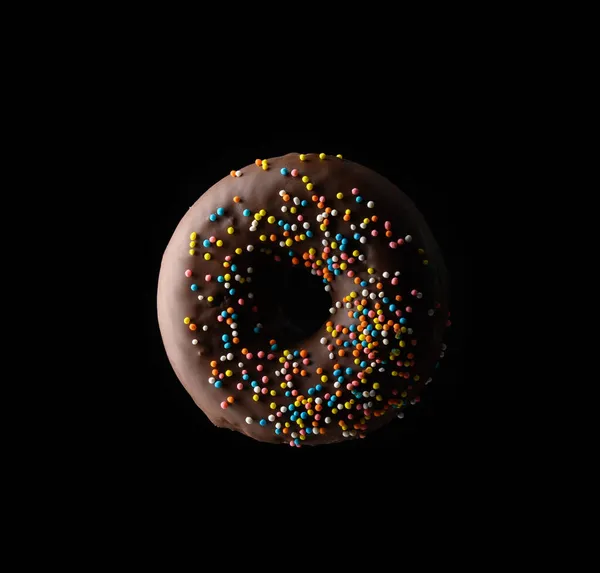 Chocolade Donuts Met Veelkleurige Hagelslag Zweven Een Zwarte Achtergrond — Stockfoto