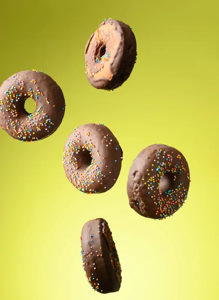 Chocolade Ronde Donuts Met Veelkleurige Suiker Hagelslag Zweven Een Groene — Stockfoto