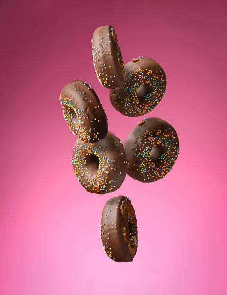 Chocolade Ronde Donuts Met Veelkleurige Suiker Hagelslag Zweven Een Roze — Stockfoto