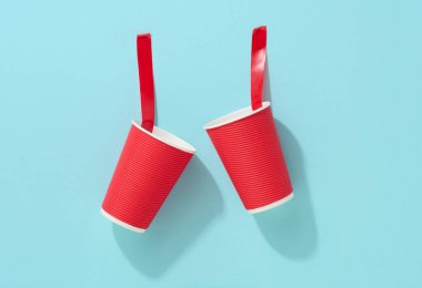 Kırmızı karton fincana yapıştırılmış kırmızı yapışkan bantla mavi arka plan