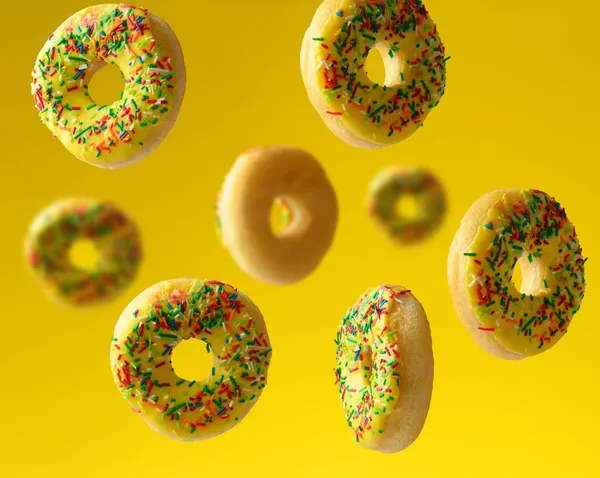 Ronde Gebakken Donuts Bestrooid Met Veelkleurige Suiker Besprenkel Zweven Een — Stockfoto