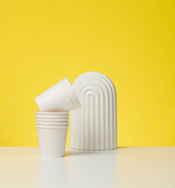 Kahve için karton beyaz bardaklar, sarı arka plan. Çevre dostu sofra takımı, sıfır atık