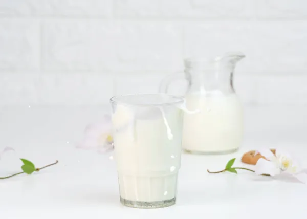 Volle Glasschale Mit Frischer Milch Mit Spritzern Steht Auf Einem — Stockfoto