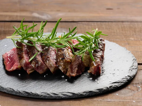 Pedazo Frito Carne Vaca Ribeye Cortado Pedazos Sobre Tabla Negra —  Fotos de Stock