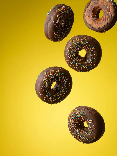 Chocolade Ronde Donuts Met Veelkleurige Suiker Hagelslag Zweven Een Gele — Stockfoto