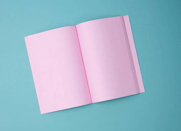 Otevřený Zápisník Prázdnými Růžovými Listy Modrém Pozadí Horní Pohled — Stock fotografie