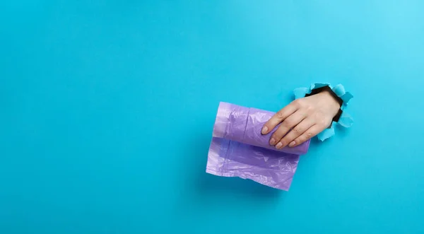 Жіноча Рука Тримає Пучок Прозорих Мішків Сміття Синьому Фоні Частина — стокове фото