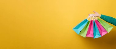 Kadın eli, alışveriş ve giysi için tek kullanımlık kağıt bir çanta tutuyor. Geri dönüşümlü ambalaj. Sıfır kayıp. Satış afişi