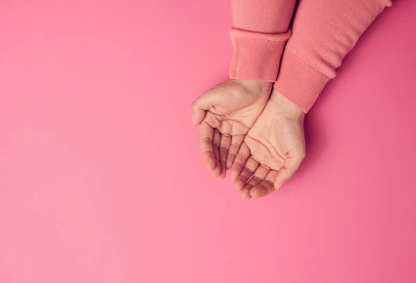 Två Kvinnliga Händer Vikta Handflatan Till Handflatan Rosa Bakgrund Ovanifrån — Stockfoto