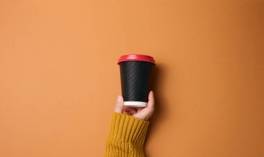 Kahve için kağıt karton bardakla el ele tutuşun. Çevre dostu sofra takımı