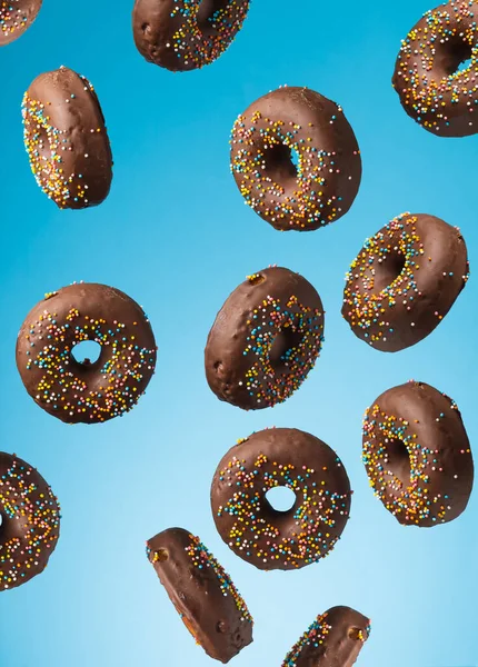 Шоколадные Круглые Пончики Разноцветной Сахарной Крошкой Левитируют Синем Фоне — стоковое фото