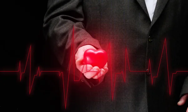 Businessman Holding Red Heart Black Background Front Him Cardiogram Office — Foto Stock