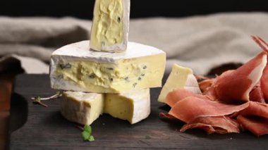 Tahtada dilimlenmiş jamon ve mavi peynir, kahvaltı. Kamera hareketi sağa.