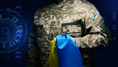 Ukrayna silahlı kuvvetlerinin askeri siyah bir arka planda mavi-sarı Ukrayna bayrağıyla duruyor. Gazileri onurlandırmak ve savaşta ölenleri anmak.