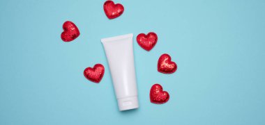 Mavi arka planda kozmetik ürünleri için boş beyaz plastik tüpler. Krem, jel, serum, reklam ve ürün tanıtımı için ambalaj, maket