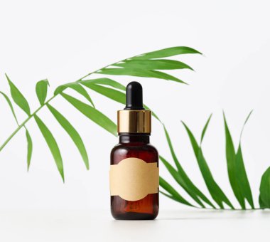 Üzerinde boş etiket ve pipet olan kahverengi cam bir şişe. Kozmetik ambalajlama, reklam ve promosyon