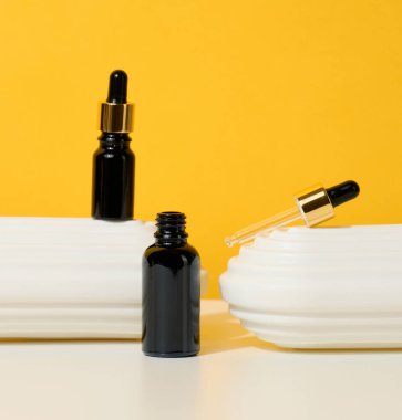 Pipetli kahverengi cam şişe beyaz bir masada duruyor. Kozmetik SPA markası. Jel, serum, reklam ve ürün tanıtımı için ambalaj, maket