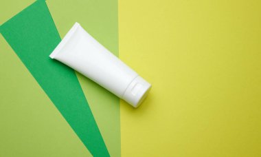 Kozmetik için beyaz plastik tüpleri boşalt. Krem, jel, serum, reklam ve ürün tanıtımı için ambalaj, yeşil arkaplan
