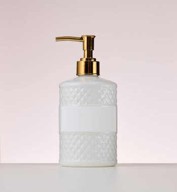 Bej kaplamalı beyaz plastik konteynır. Sıvı sabun için kap, şampuan.