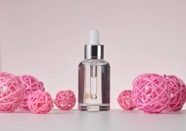 Cam şeffaf beyaz şişe ve pipet. Bej bir arka planda kozmetik, asit ve yağlar için konteyner