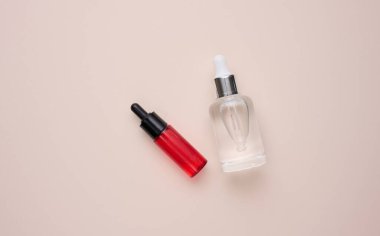 Cam şeffaf beyaz şişe ve pipet. Bej bir arka planda kozmetik, asit ve yağlar için konteyner