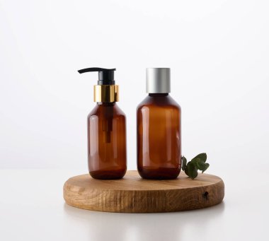 Kozmetik sıvısı ürünleri için beyaz arka planda spreyli kahverengi cam şişe. Kozmetik sıvı ürünleri, reklamcılık ve tanıtım şablonu