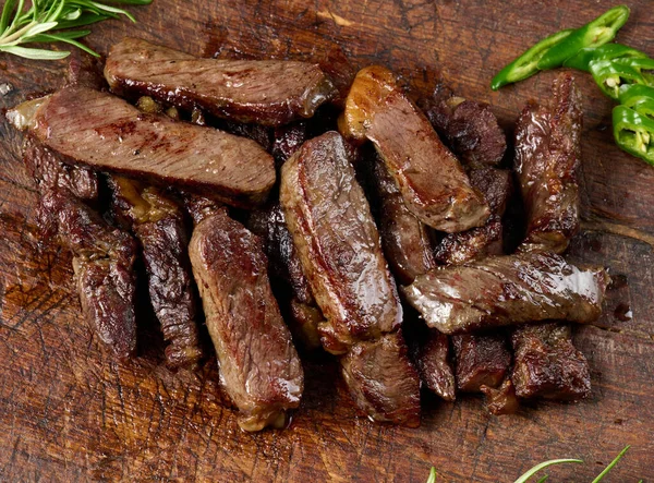 Kızarmış Biftek Parçalarını Eski Kahverengi Bir Doğrama Tahtasıyla Parçalara Ayırdım — Stok fotoğraf