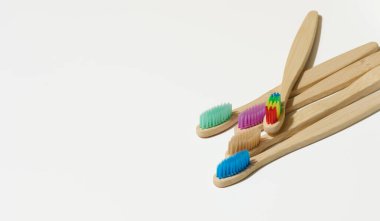 Beyaz arka planda tahta diş fırçaları, sıfır atık. Üst görünüm