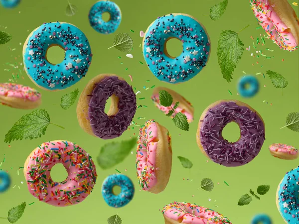 Zoete Veelkleurige Donuts Zweven Een Groene Achtergrond Suiker Hagelslag Vliegen — Stockfoto