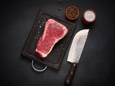 Taze çiğ et, siyah arka planda çizgili biftek, üst manzara. Mermer et parçası New York