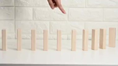 Beyaz bir masanın üzerine düşen tahta bloklar, parmak ilk bloğu itiyor. Zayıf takım konsepti, akıl sağlığı. Dış çevrenin zayıflamış bir insan üzerindeki etkisi